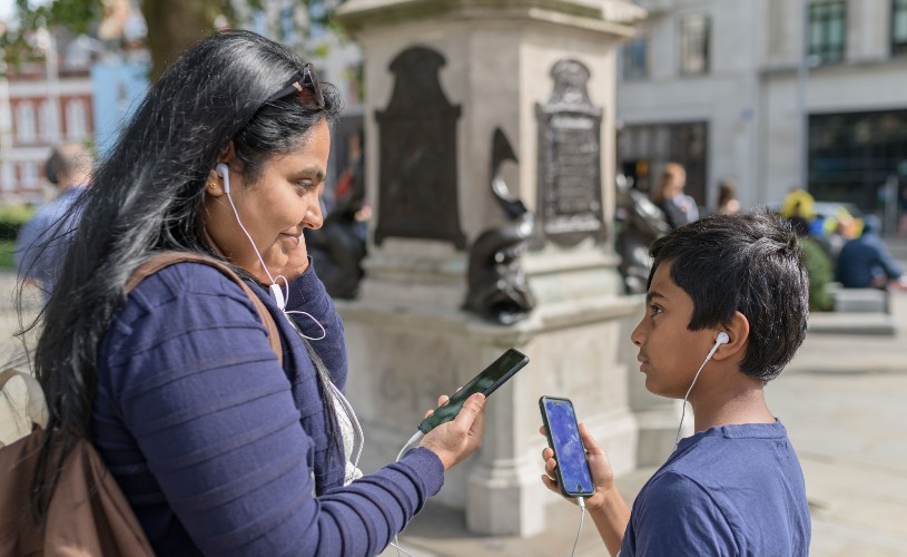 Mum and son with phones and headphones on Bristol Open Doors walking tour